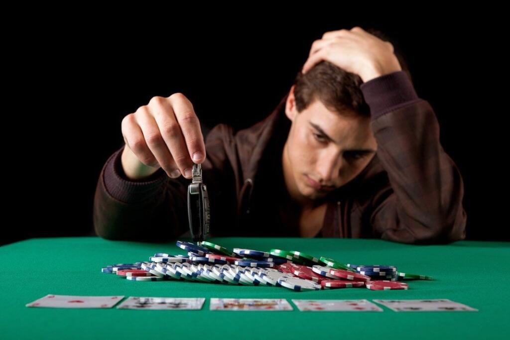Man gambling with poker chips and car keys, reflecting struggle