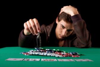Man gambling with poker chips and car keys, reflecting struggle