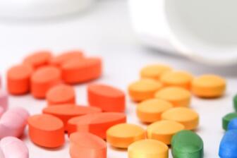 Colourful pills and tablets for addiction recovery scattered on a clean white surface