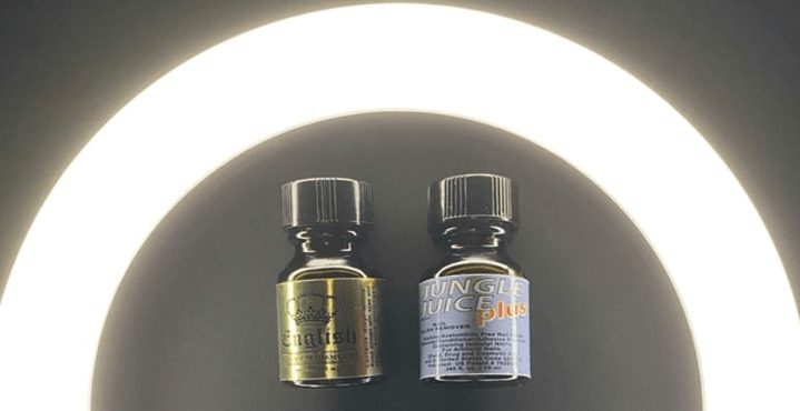 Two small poppers bottles with labels under bright light